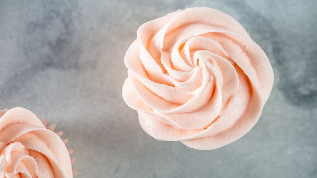 cupcake topped with classic pink buttercream frosting made with Domino® Powdered Sugar