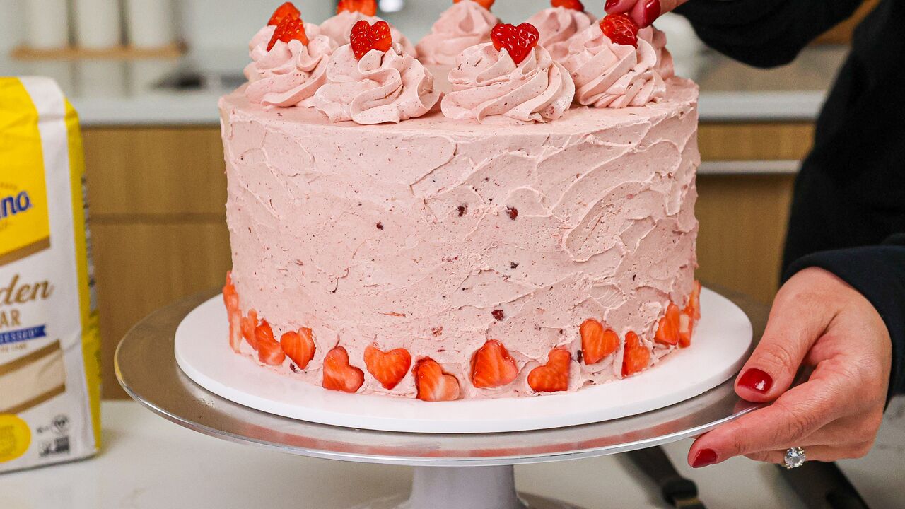 domino golden sugar strawberry layer cake with strawberry frosting and heart-shaped strawberries