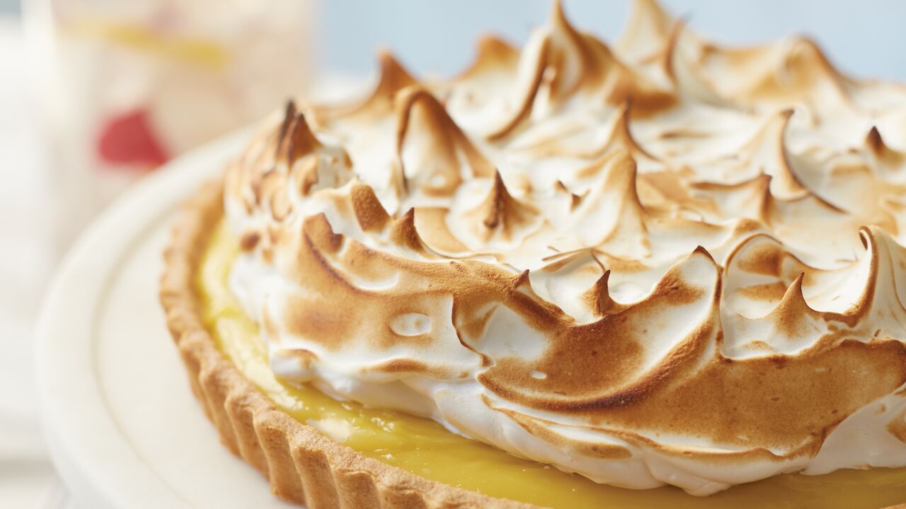 A lemon meringue pie artfully displayed on a plate